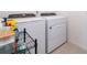 Bright laundry room with modern, white washer and dryer units and gray tiled flooring at 3134 Viceroy Ct, Poinciana, FL 34759