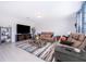 A spacious living room featuring tile flooring, large TV, and comfortable leather couches at 3134 Viceroy Ct, Poinciana, FL 34759