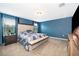 Spacious main bedroom with blue walls, plush carpet, wooden bedside table, and a large window with natural light at 3134 Viceroy Ct, Poinciana, FL 34759