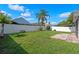 Spacious backyard with a white fence, lush grass, and a shade palm tree at 3220 Harpers Ferry Ct, Orlando, FL 32837