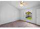 Comfortable carpeted bedroom with ceiling fan and a window overlooking a fenced yard with a mature tree at 3220 Harpers Ferry Ct, Orlando, FL 32837