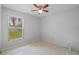 Neutral bedroom with ceiling fan and tile flooring, providing a serene and functional space with natural light from the window at 3220 Harpers Ferry Ct, Orlando, FL 32837