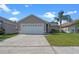 Charming single-story home featuring a concrete driveway, a two-car garage and a well-manicured lawn at 3220 Harpers Ferry Ct, Orlando, FL 32837