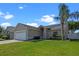 Lovely single-story home with a two-car garage, lush green lawn, and mature palm tree enhancing curb appeal at 3220 Harpers Ferry Ct, Orlando, FL 32837