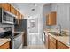 Well-lit kitchen with stainless steel appliances, wooden cabinetry, and bright tile flooring, offering a clean aesthetic at 3220 Harpers Ferry Ct, Orlando, FL 32837