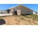 Beige single-story home with a concrete patio and a blank canvas ready for landscaping at 4026 Ruby Run, Haines City, FL 33844