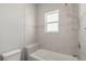 A tub/shower combination with tiled walls and a small window at 4026 Ruby Run, Haines City, FL 33844