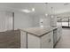 Kitchen island featuring granite countertops, stainless steel appliances, and modern pendant lighting at 4026 Ruby Run, Haines City, FL 33844