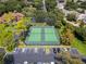 This aerial view shows two tennis courts with surrounding green trees and nearby parking at 420 Forestway Cir # 108, Altamonte Springs, FL 32701