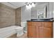 This bathroom features a shower-tub, wooden vanity, decorative mirror, and tile flooring at 420 Forestway Cir # 108, Altamonte Springs, FL 32701