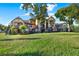 This exterior view shows a well-maintained, multi-story apartment building with lush green trees in the front at 420 Forestway Cir # 108, Altamonte Springs, FL 32701