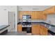 Kitchen with wood cabinets, granite countertops, stainless appliances, and tile flooring at 420 Forestway Cir # 108, Altamonte Springs, FL 32701