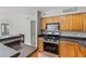 Well-equipped kitchen featuring granite countertops, wood cabinets, and stainless steel oven at 420 Forestway Cir # 108, Altamonte Springs, FL 32701