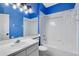 A bright bathroom features blue walls, white fixtures, shower-tub combo, and mirror at 4579 Westgrove Way, Orlando, FL 32808