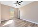 A well-lit bedroom boasts a modern ceiling fan, window, and attractive wood-look laminate flooring at 4579 Westgrove Way, Orlando, FL 32808