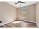 A serene bedroom featuring modern ceiling fan, window, and wood-look laminate flooring at 4579 Westgrove Way, Orlando, FL 32808