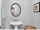 Powder room with a pedestal sink and decorative mirror at 4833 Palm Tree Ct, Windermere, FL 34786