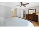 Well-lit bedroom with light walls, wood floors, ceiling fan, and view into the bathroom and living area at 4833 Palm Tree Ct, Windermere, FL 34786