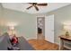 Bedroom showcasing a futon, open door to the living room, and a ceiling fan at 4833 Palm Tree Ct, Windermere, FL 34786