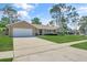 Tan single-story home with attached two-car garage and a spacious concrete driveway at 4833 Palm Tree Ct, Windermere, FL 34786