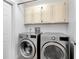 Laundry room with modern washer and dryer units and storage cabinets at 4833 Palm Tree Ct, Windermere, FL 34786