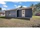 A spacious backyard with lush grass, back door access, and a modern exterior at 510 Fahnstock St, Eustis, FL 32726