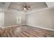 Primary bedroom featuring wood floors, a tray ceiling, a ceiling fan, and natural light at 510 Fahnstock St, Eustis, FL 32726