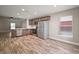 Open kitchen with stainless steel appliances and wood floors and view to adjacent living area at 510 Fahnstock St, Eustis, FL 32726
