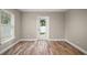 Bright living room with wood floors, white trim, and a window view to the backyard at 510 Fahnstock St, Eustis, FL 32726