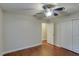 A cozy bedroom with a ceiling fan, closet, and wood-look flooring at 5518 Cretan Way, Winter Park, FL 32792