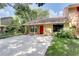 Charming home featuring stone accents, a bright red front door, and well-maintained lawn at 5518 Cretan Way, Winter Park, FL 32792
