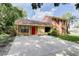 Charming two-story home with stone accents, a bright red front door, and a spacious driveway at 5518 Cretan Way, Winter Park, FL 32792