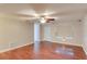 Living room featuring wood-look floors, ceiling fan, and a bright white door at 5518 Cretan Way, Winter Park, FL 32792