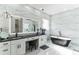 Bright primary bathroom boasts double vanity, statement tub and glass shower at 5531 Dallas Blvd, Orlando, FL 32833