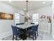Elegant dining room features a marble-top table with blue chairs and a modern chandelier at 5531 Dallas Blvd, Orlando, FL 32833