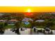 Aerial view of grand estate, nestled amongst trees with private docks and waterfront access at sunset at 570 Manor Rd, Maitland, FL 32751