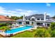 Aerial view of a large pool, back patio, and lush landscaping complimenting an elegant white home at 570 Manor Rd, Maitland, FL 32751