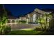 Elegant two-story home with a stone archway entrance, lush landscaping, and an expansive paved driveway at 570 Manor Rd, Maitland, FL 32751