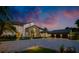 Beautiful two-story home at dusk with a stone archway entrance, circular driveway, and lush landscaping at 570 Manor Rd, Maitland, FL 32751