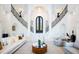 A grand foyer with a dual staircase, exquisite lighting, and elegant decor that welcomes you to the property at 570 Manor Rd, Maitland, FL 32751