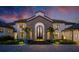 Close up of a stunning two-story home with a stone archway entrance, and lush landscaping at 570 Manor Rd, Maitland, FL 32751