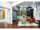 Modern home office with glass walls, built-in shelving, custom desk, and stylish decor at 570 Manor Rd, Maitland, FL 32751
