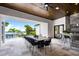 Covered outdoor dining area with stone fireplace, bar, and a lake view at 570 Manor Rd, Maitland, FL 32751