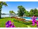 Picturesque backyard with a sparkling pool, lush landscaping, and a charming gazebo by the waterfront at 570 Manor Rd, Maitland, FL 32751
