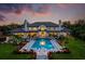 Backyard with a large in-ground pool and sun loungers, set against a beautiful, modern estate at sunset at 570 Manor Rd, Maitland, FL 32751