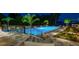 Nighttime view of a luxury pool area with lounge chairs, surrounded by professionally designed landscaping and an attractive patio at 570 Manor Rd, Maitland, FL 32751