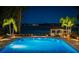 Backyard featuring a swimming pool with spa, outdoor seating area, lush landscaping, and a waterfront view at 570 Manor Rd, Maitland, FL 32751