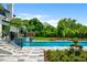 Stunning pool with lush landscaping, tiled deck, and stairs leading to a covered dining area at 570 Manor Rd, Maitland, FL 32751
