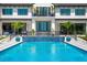 Backyard pool with waterfall feature, surrounded by lush landscaping and a modern home exterior with balconies at 570 Manor Rd, Maitland, FL 32751