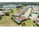 Aerial view of home with screened pool, pond and view of the neighborhood at 5799 Linen Bluff Pl, Leesburg, FL 34748